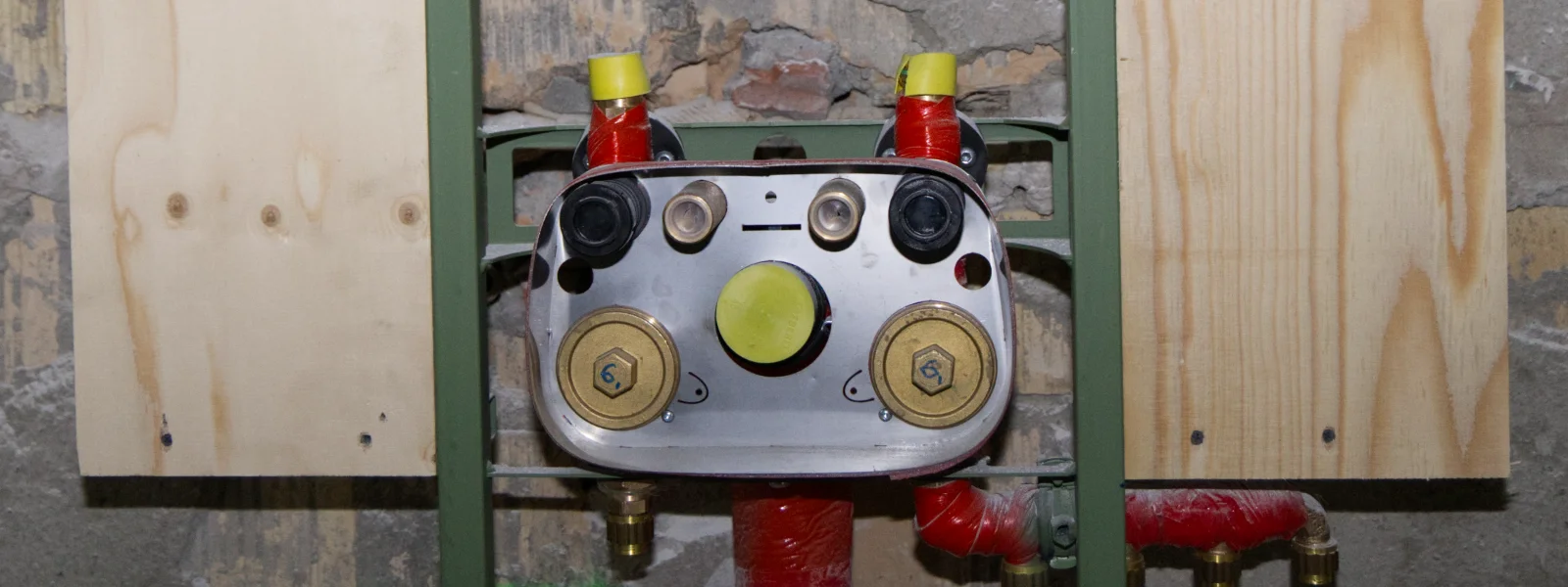 Heizungsverteiler und Rohranschlüsse bei der Installation von Gebäudetechnik